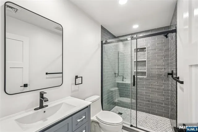 a bathroom with a sink mirror shower and toilet
