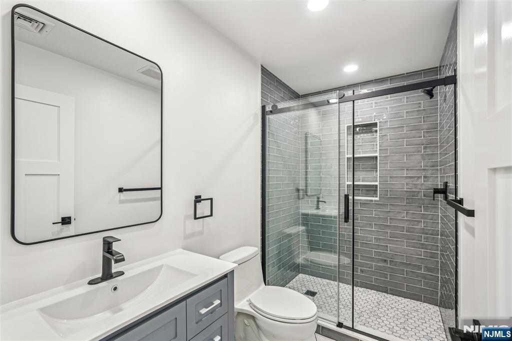 492 Oaktree Road Oradell, NJ 07649 - Photo 26 of 43 a bathroom with a sink mirror shower and toilet
