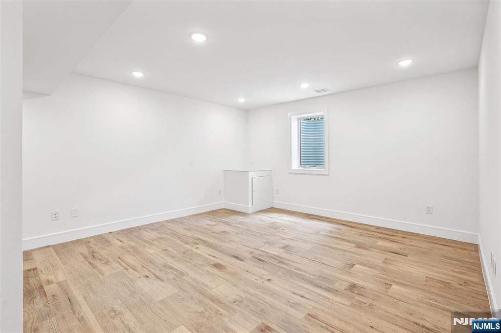 492 Oaktree Road Oradell, NJ 07649 - Photo 34 of 43 an empty room with wooden floor and windows