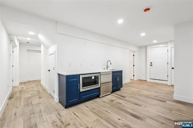 a view of a kitchen with stainless steel appliances wooden cabinets and wooden floor