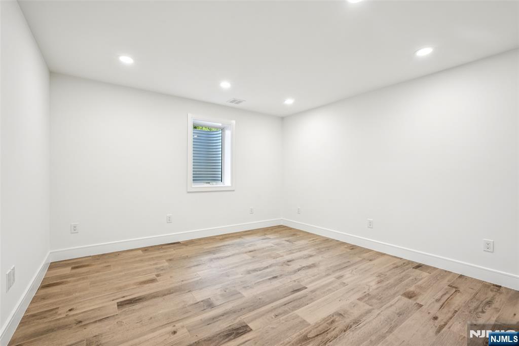 492 Oaktree Road Oradell, NJ 07649 - Photo 37 of 43 an empty room with wooden floor and windows