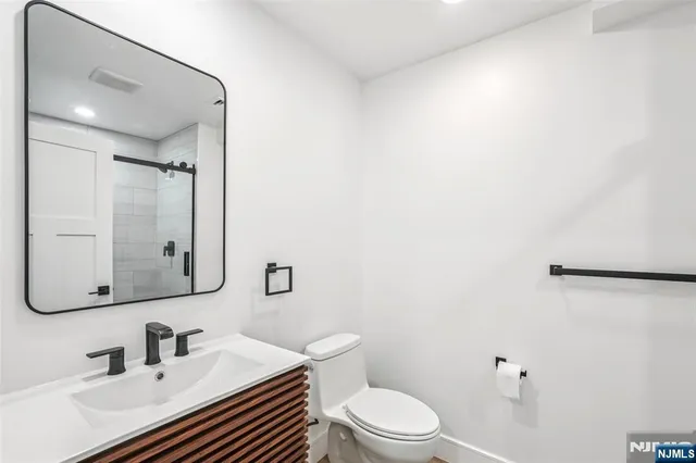a bathroom with a sink a toilet a mirror and vanity