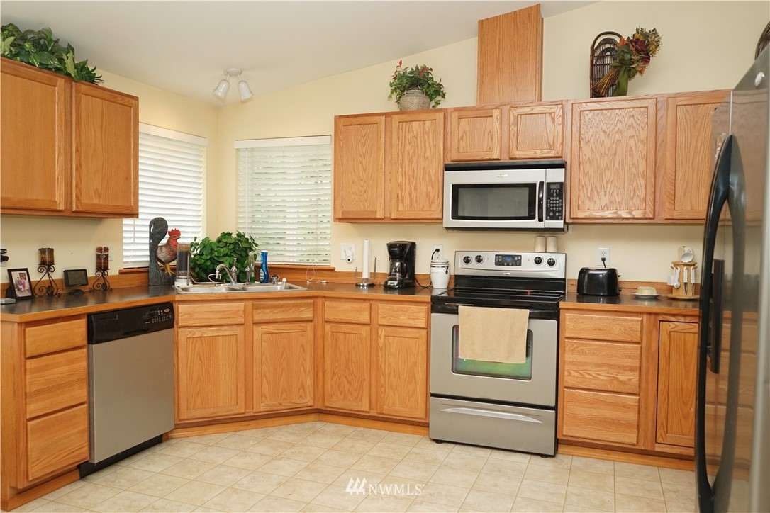 16823 Leitner Road Southwest Rochester, WA 98579 - Photo 11 of 31 a kitchen with granite countertop white cabinets and stainless steel appliances