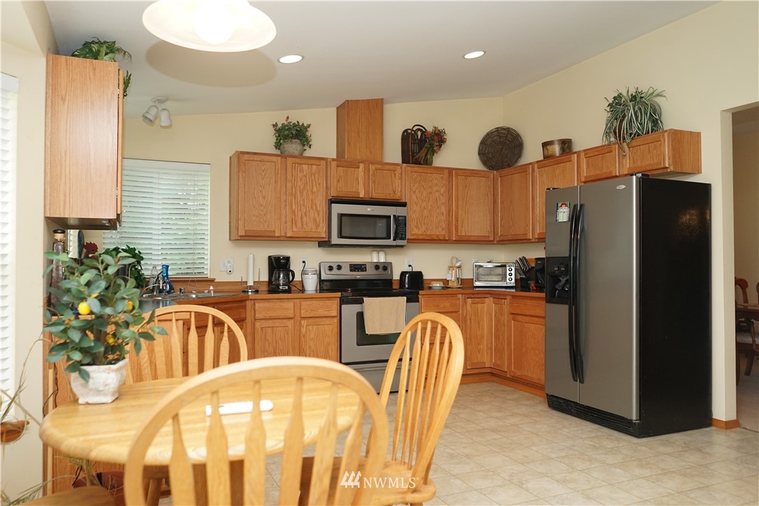 16823 Leitner Road Southwest Rochester, WA 98579 - Photo 13 of 31 a kitchen with stainless steel appliances granite countertop a refrigerator a stove top oven a sink and dishwasher