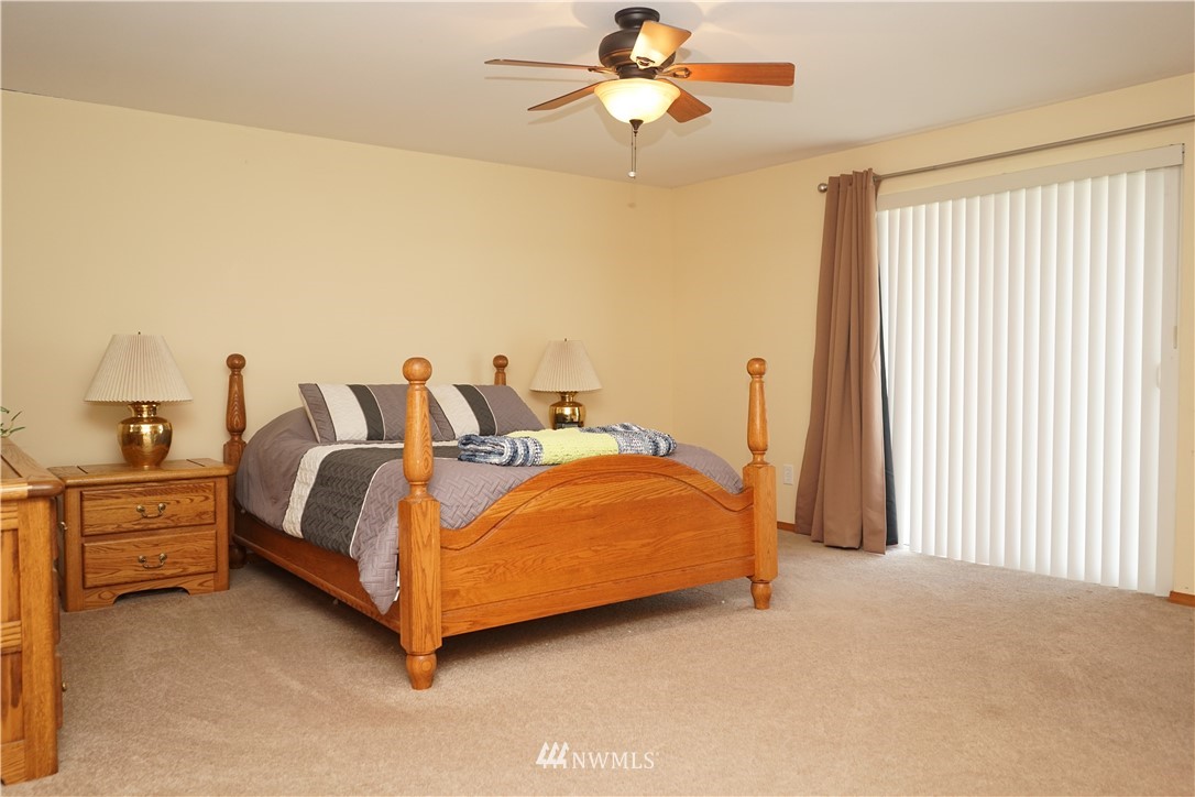 16823 Leitner Road Southwest Rochester, WA 98579 - Photo 22 of 31 a spacious bedroom with a bed and a chandelier