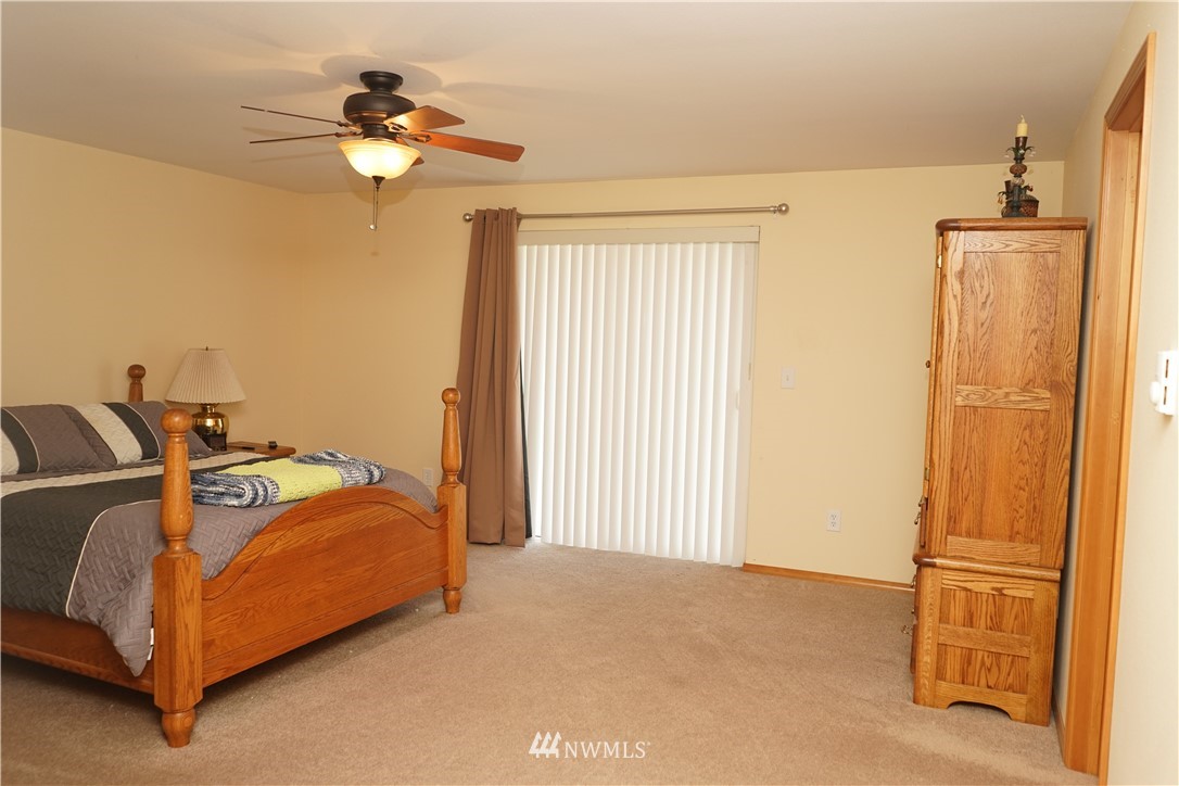 16823 Leitner Road Southwest Rochester, WA 98579 - Photo 23 of 31 a bed room with a bed and a chandelier