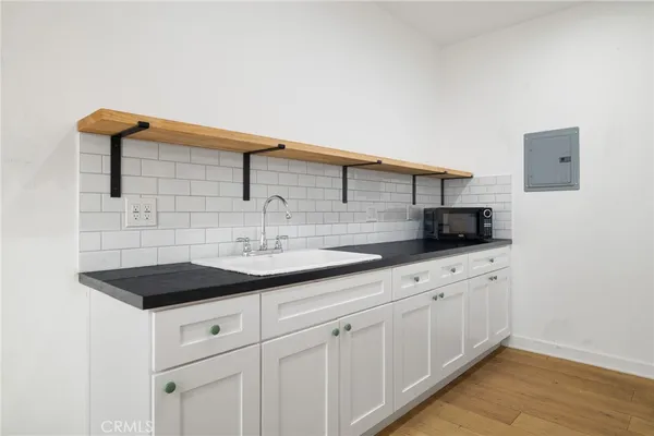 a kitchen with white cabinets a sink and dishwasher