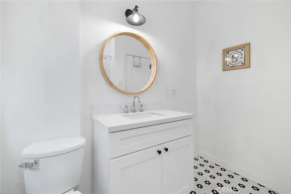 a bathroom with a sink a toilet and a mirror