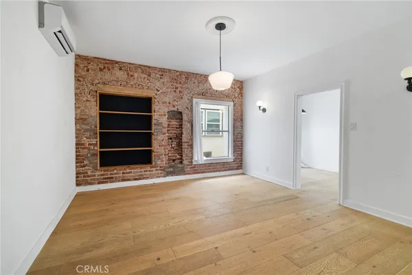 a view of an empty room with a fireplace and a window