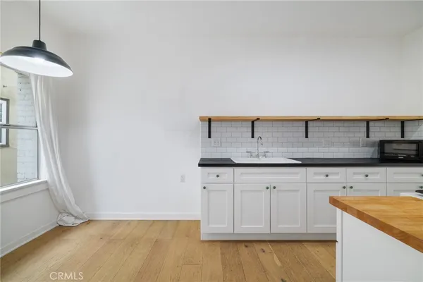 a kitchen with granite countertop a sink a stove and cabinets
