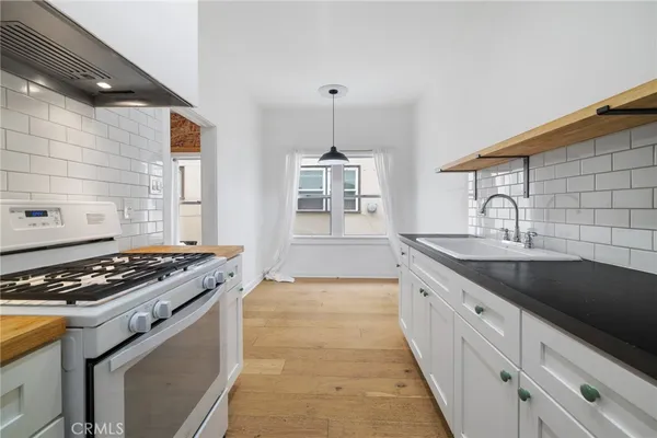 a kitchen with granite countertop a sink stove and cabinets