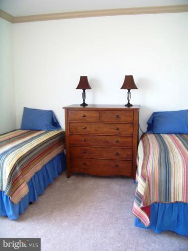 14642 Solomons Island Road South, Unit 2 Solomons, MD 20688 - Photo 8 of 14 a bedroom with a bed and a night stand