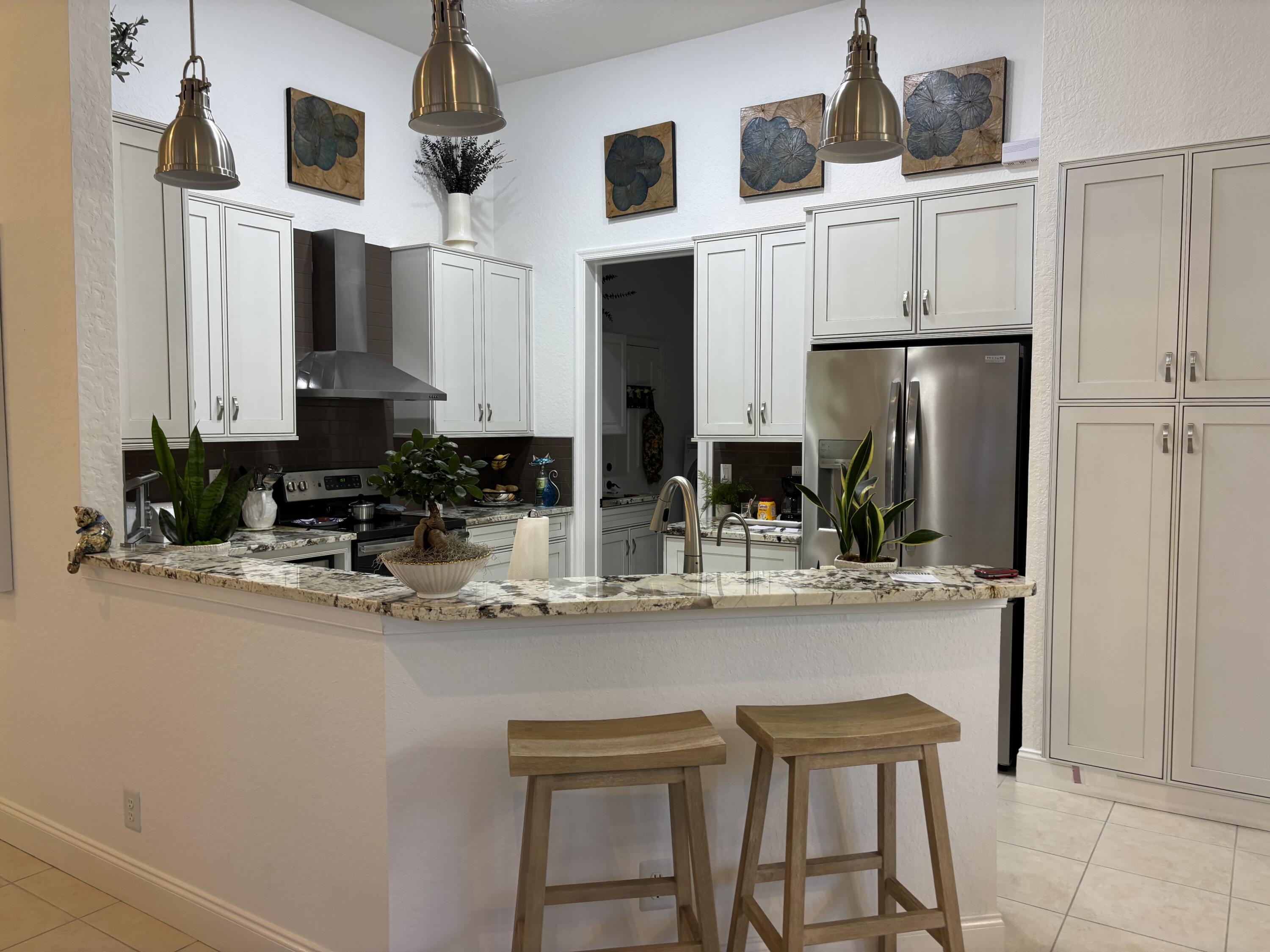 140 Via Rosina Jupiter, FL 33458 - Photo 4 of 16 a kitchen with stainless steel appliances granite countertop a sink and cabinets