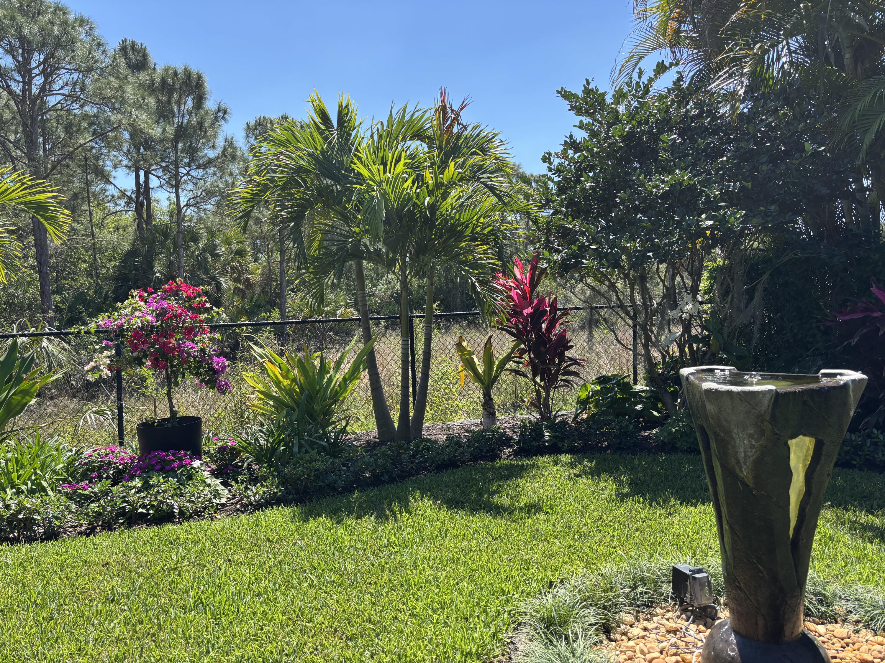 140 Via Rosina Jupiter, FL 33458 - Photo 8 of 16 a view of a flower in a yard with potted plants