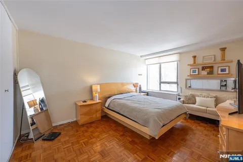 a bedroom with a bed and a flat tv screen on dresser