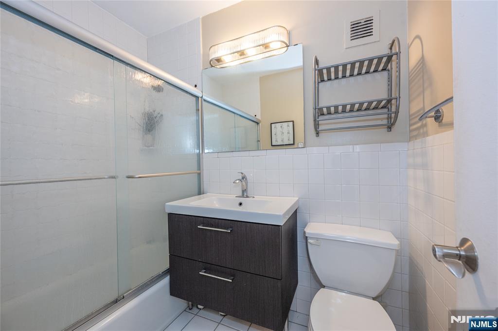 1 Horizon Road, Unit 403 Fort Lee, NJ 07024 - Photo 17 of 29 a bathroom with a toilet sink and mirror