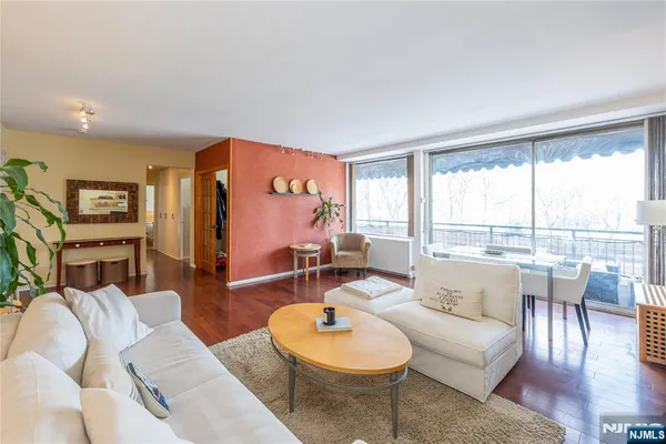 a living room with furniture a fireplace and a floor to ceiling window