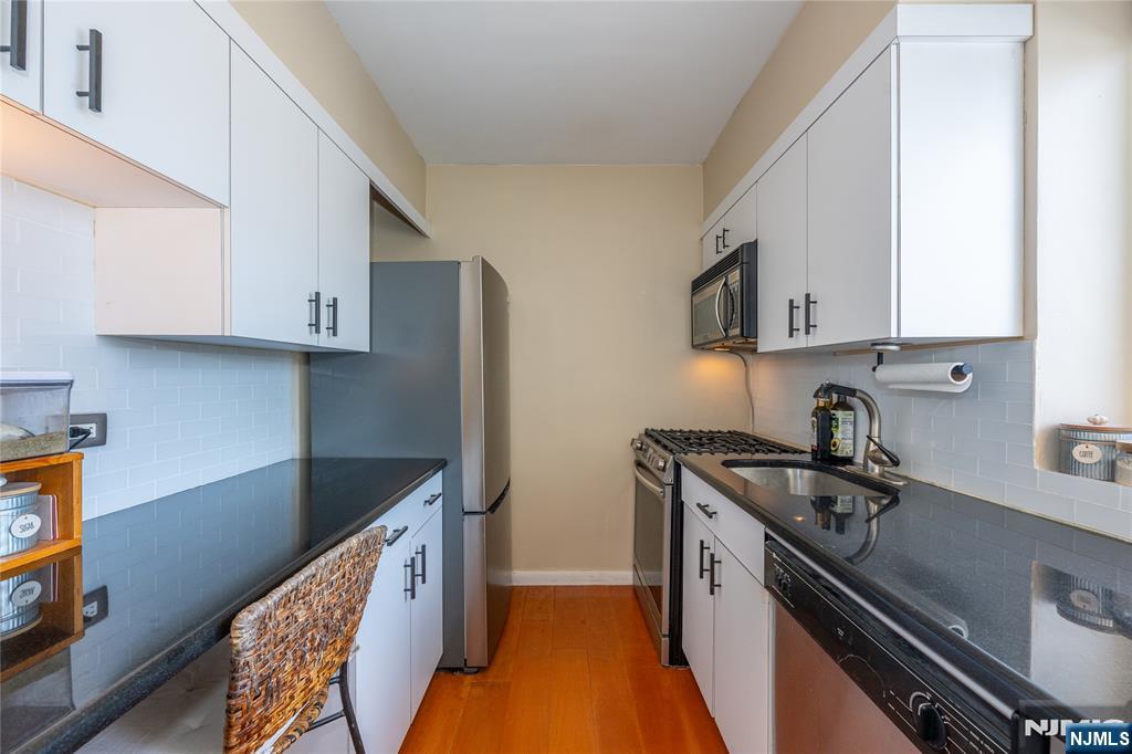1 Horizon Road, Unit 403 Fort Lee, NJ 07024 - Photo 9 of 29 a kitchen with stainless steel appliances granite countertop a sink stove and cabinets