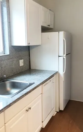 a kitchen with granite countertop white cabinets and white appliances