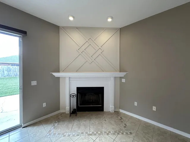 an empty room with a fireplace and a window