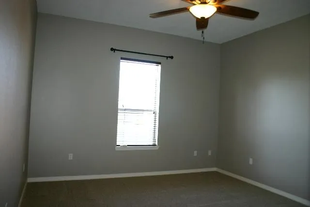 an empty room with a chandelier fan