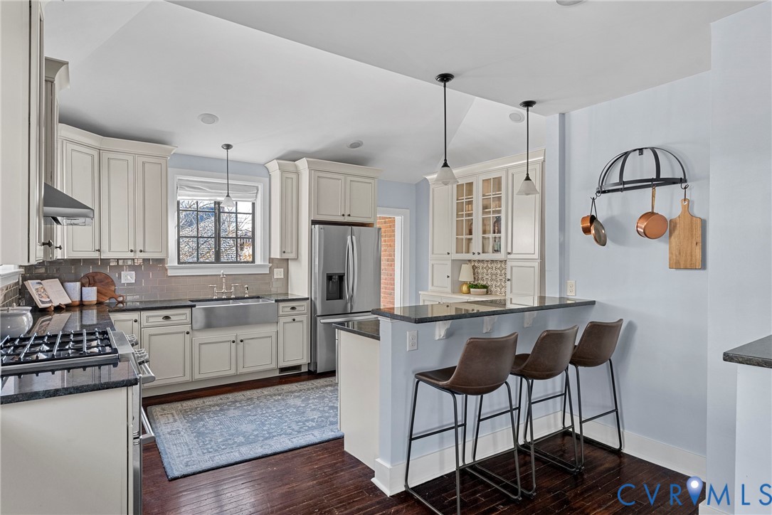 803 Spottswood Road Richmond, VA 23220 - Photo 12 of 50 a kitchen with stainless steel appliances granite countertop a stove a refrigerator a sink dishwasher a dining table and chairs with wooden floor