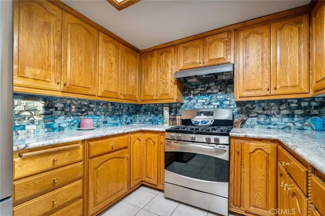 a kitchen with stainless steel appliances granite countertop a sink a stove and a wooden floors