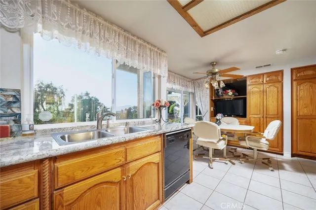 a view of an empty room with a window and kitchen view