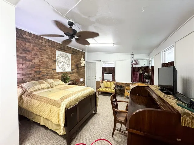 a bedroom with bed tv and window