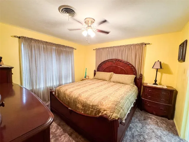 a bedroom with a bed and dresser with mirror