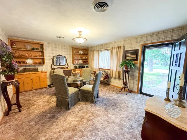 a living room with furniture a large window and kitchen view