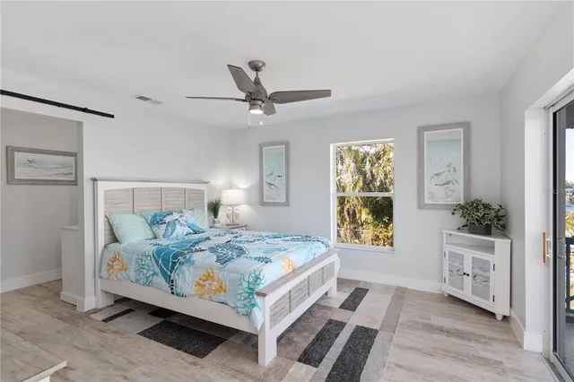 a bedroom with a bed a dresser and potted plants