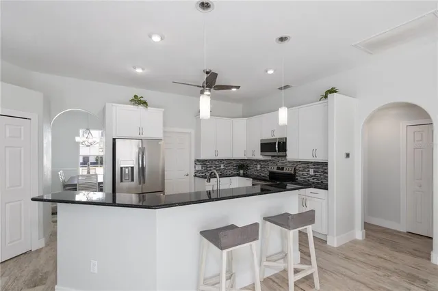 a kitchen with stainless steel appliances kitchen island granite countertop a sink and cabinets