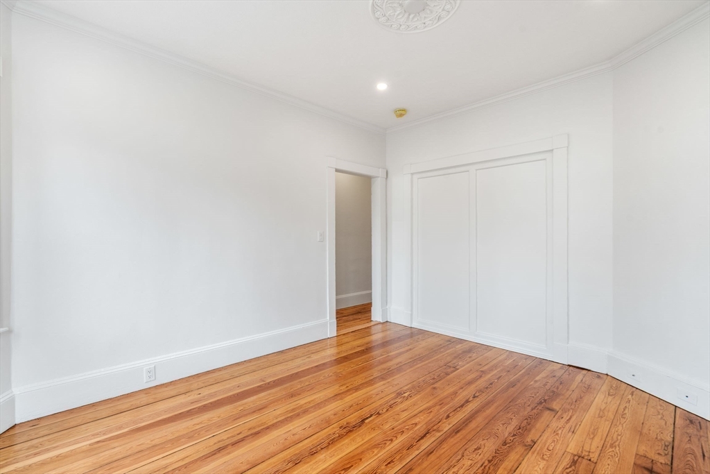 93 Sydney Street, Unit 3 Boston, MA 02125 - Photo 11 of 28 a view of an empty room with wooden floor