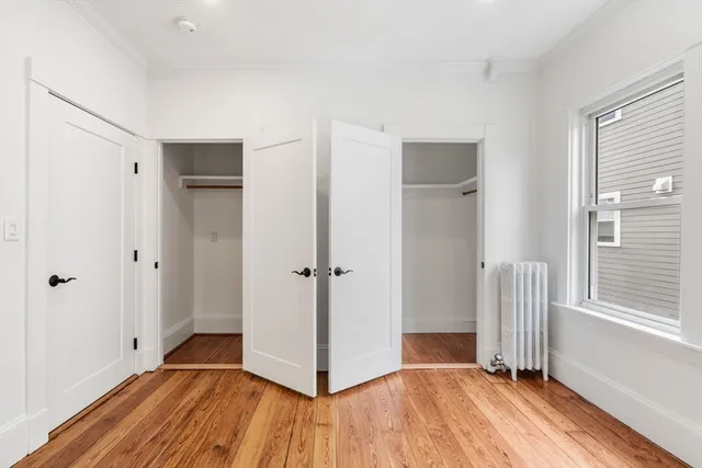 a view of a hallway with wooden floor and closet area