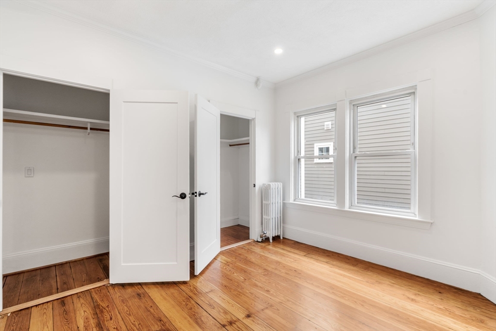 93 Sydney Street, Unit 3 Boston, MA 02125 - Photo 15 of 28 a view of an empty room with wooden floor and a window