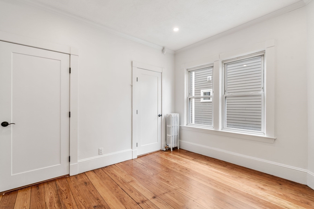 93 Sydney Street, Unit 3 Boston, MA 02125 - Photo 16 of 28 a view of an empty room with wooden floor and a window