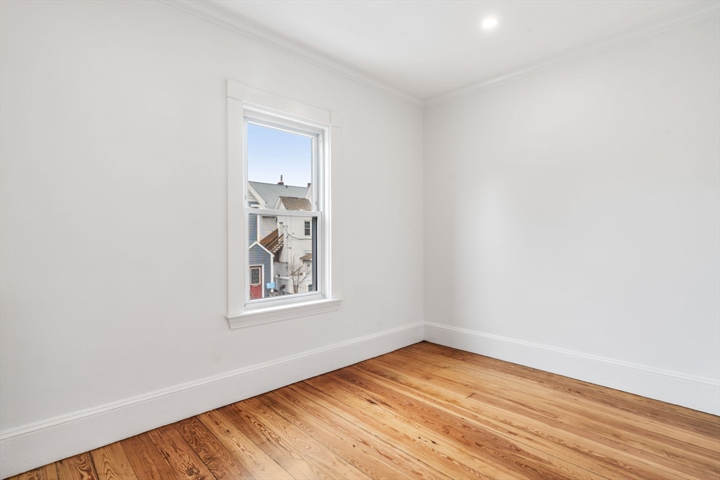 93 Sydney Street, Unit 3 Boston, MA 02125 - Photo 17 of 28 a view of an empty room with wooden floor and a window