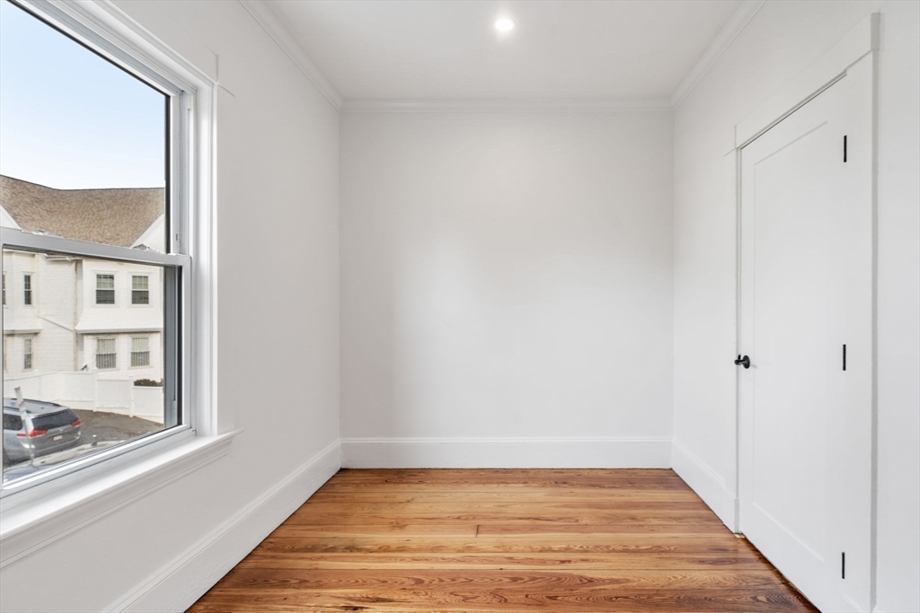 93 Sydney Street, Unit 3 Boston, MA 02125 - Photo 19 of 28 a view of an empty room with wooden floor and a window