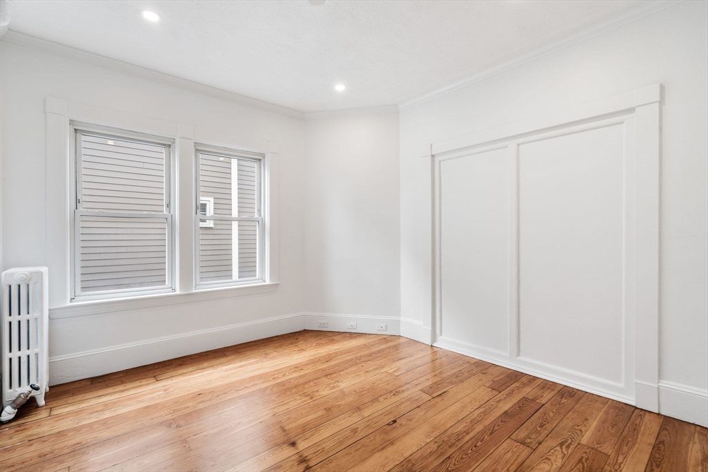 93 Sydney Street, Unit 3 Boston, MA 02125 - Photo 20 of 28 an empty room with wooden floor and windows