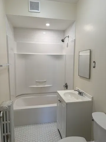 a bathroom with a bathtub a sink a toilet and a mirror