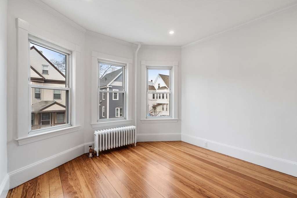 93 Sydney Street, Unit 3 Boston, MA 02125 - Photo 8 of 28 a view of an empty room with a window and wooden floor