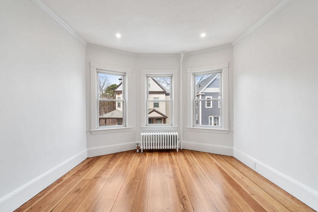 93 Sydney Street, Unit 3 Boston, MA 02125 - Photo 9 of 28 an empty room with wooden floor and windows