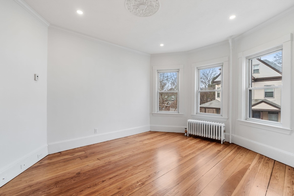 93 Sydney Street, Unit 3 Boston, MA 02125 - Photo 10 of 28 an empty room with wooden floor and windows