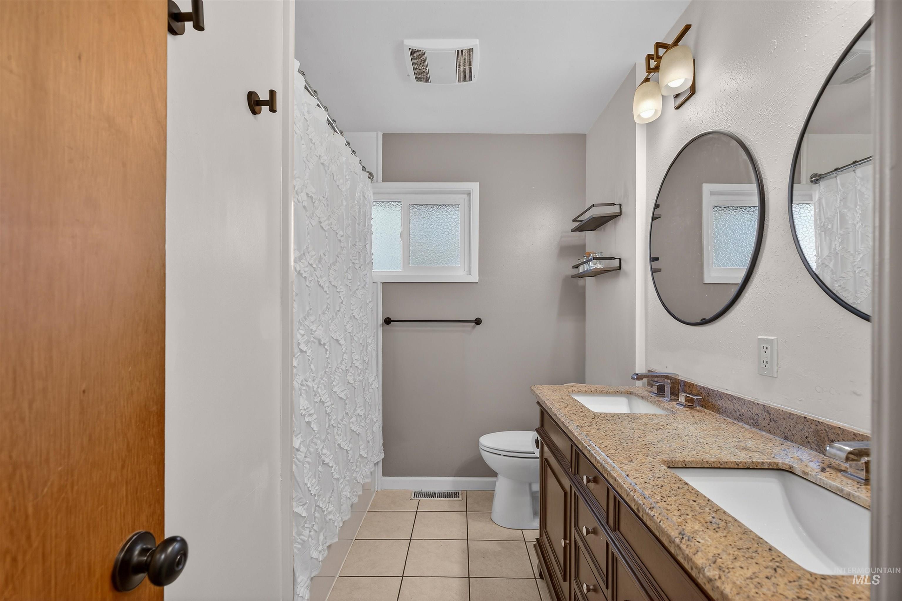 209 Walnut Drive Potlatch, ID 83855 - Photo 13 of 27 Full bath with curtained shower, double vanity, and light tile patterned flooring