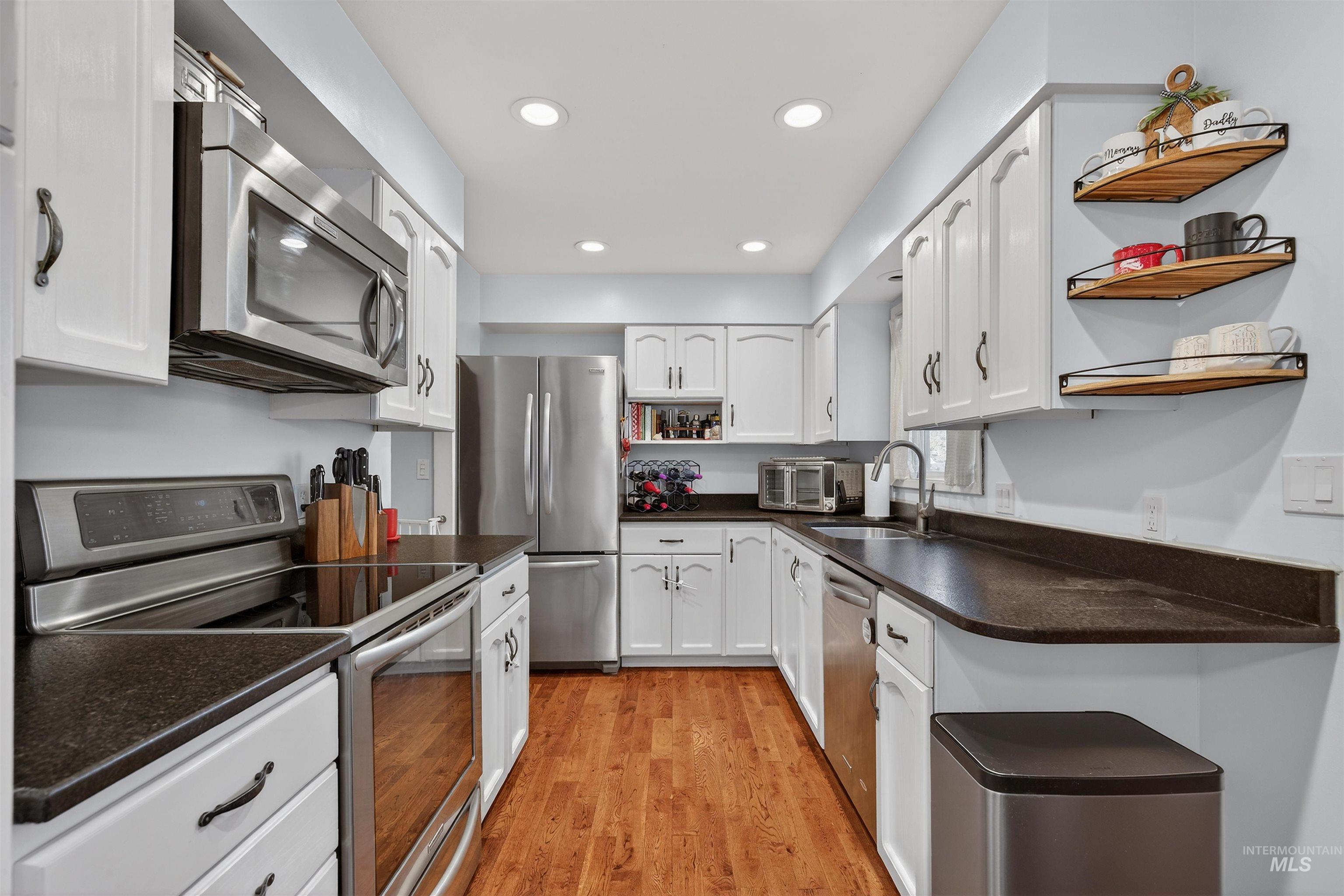 209 Walnut Drive Potlatch, ID 83855 - Photo 5 of 27 Kitchen with open shelves, stainless steel appliances, white cabinetry, light wood-type flooring, and recessed lighting