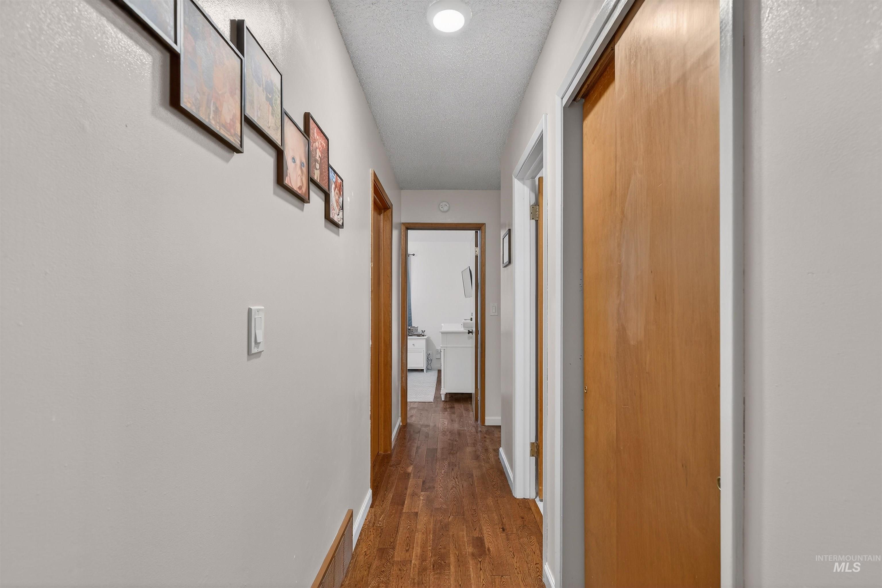 209 Walnut Drive Potlatch, ID 83855 - Photo 8 of 27 Hallway featuring a textured ceiling and dark wood-style floors