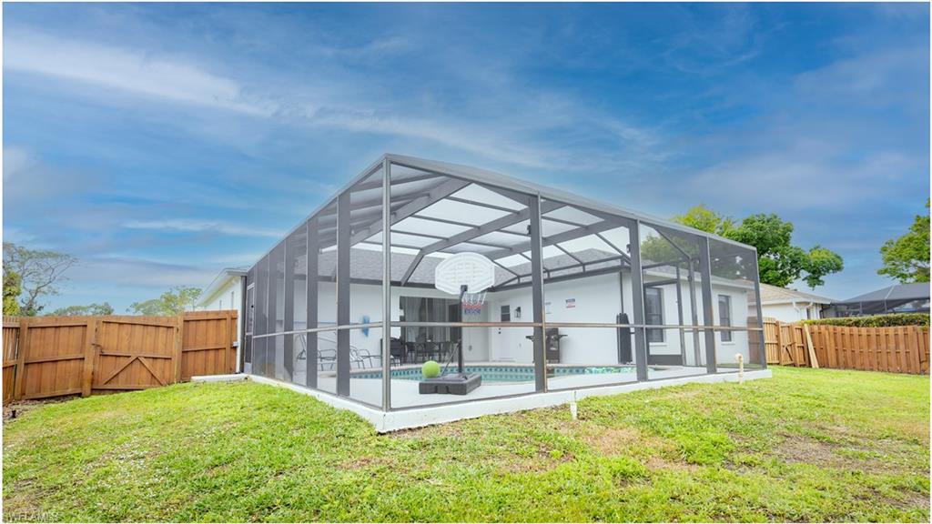 9151 Irving Road Fort Myers, FL 33967 - Photo 2 of 44 Rear view of property featuring a fenced backyard, a gate, a lanai, and a sunroom