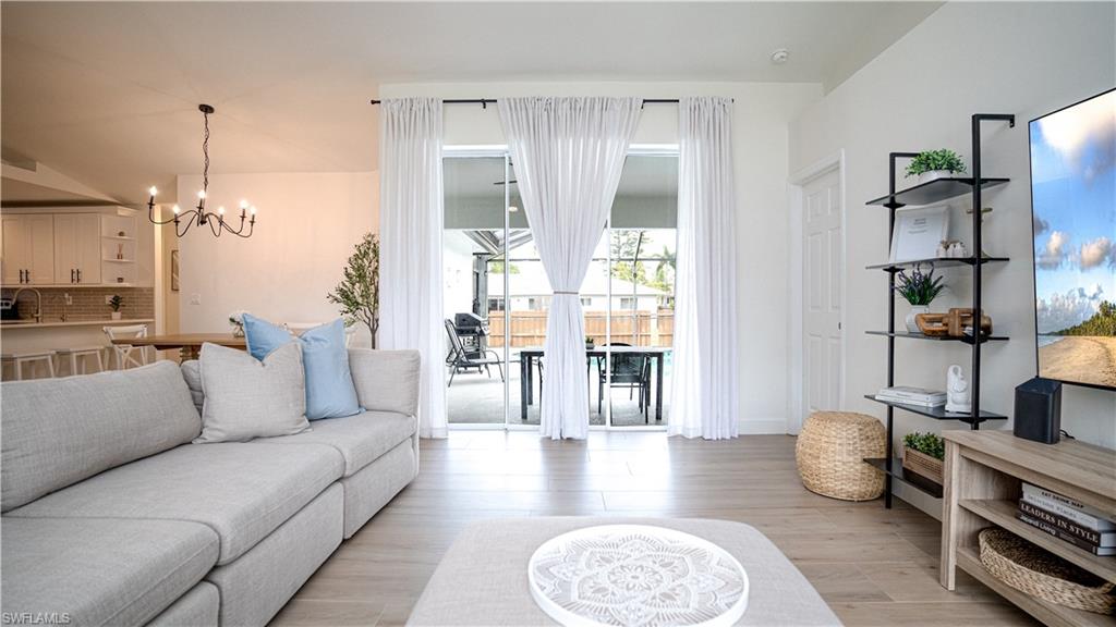 9151 Irving Road Fort Myers, FL 33967 - Photo 23 of 44 Living area featuring a chandelier and light wood-type flooring