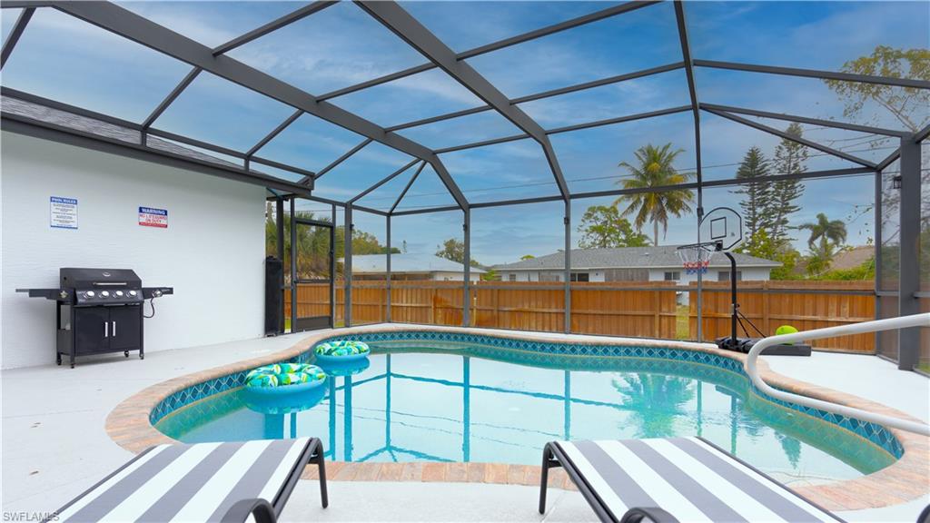 9151 Irving Road Fort Myers, FL 33967 - Photo 4 of 44 View of pool featuring a fenced backyard, a lanai, a sunroom, a grill, and a patio area